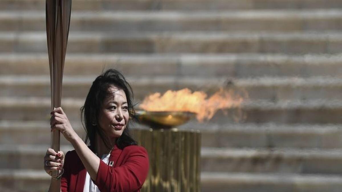 Former Japanese swimmer Imoto Naoko holds the Olympic torch during the Olympic flame handover ceremony for the 2020 Tokyo Summer Olympics, in Athens. - AP file