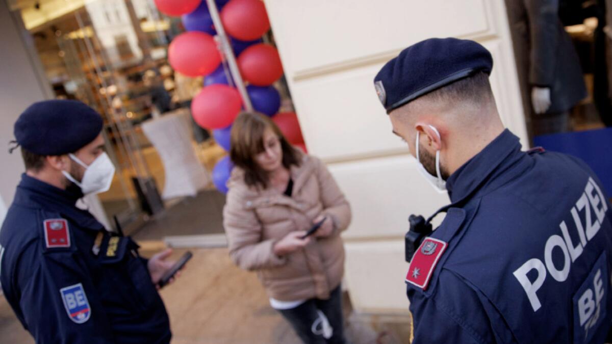 Police officers check the vaccination status of shoppers at the entrance of a store in Vienna. – Austria