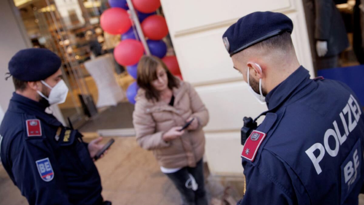 Police officers check the vaccination status of shoppers at the entrance of a store in Vienna. – Austria