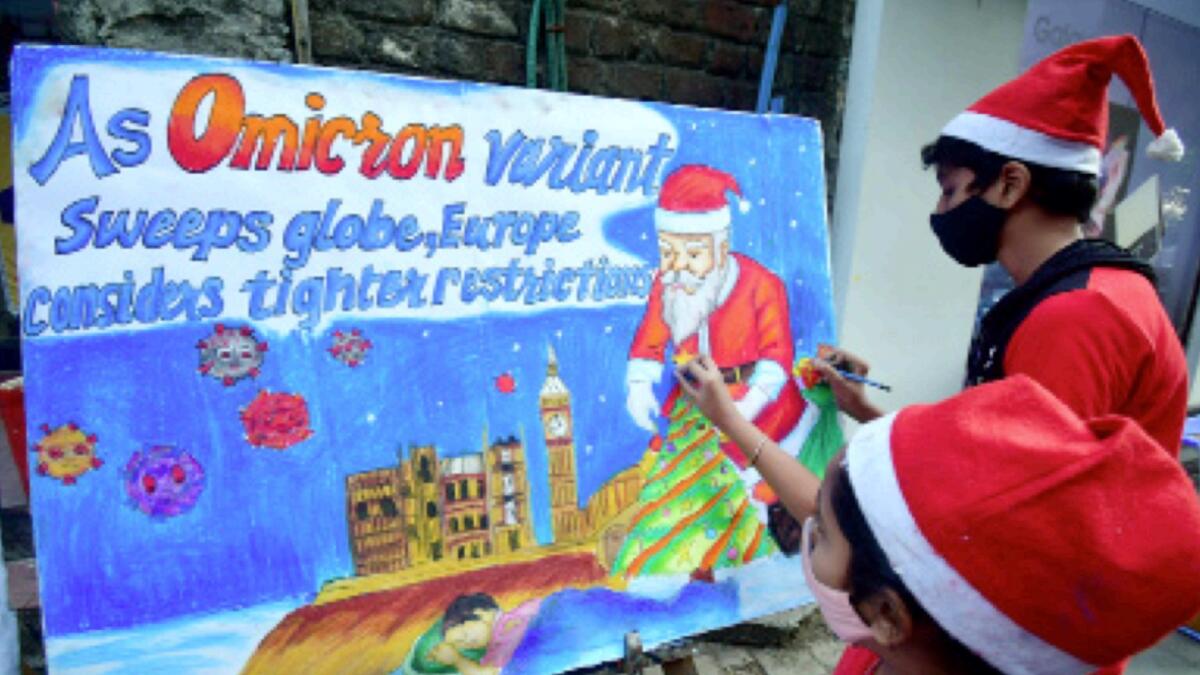 Students in Santa Claus attire make a painting with a message 'Celebrate Christmas With Care' in the wake of the Covid-19 variant Omicron, in Mumbai. — ANI