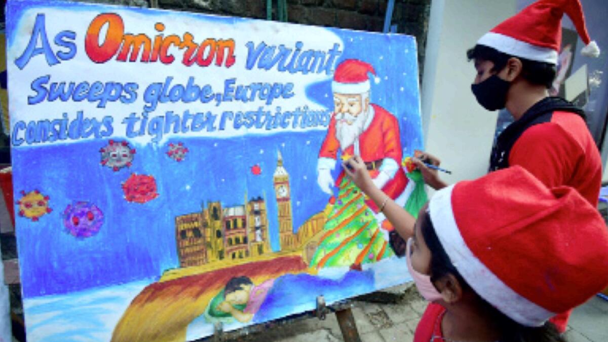 Students in Santa Claus attire make a painting with a message 'Celebrate Christmas With Care' in the wake of the Covid-19 variant Omicron, in Mumbai. — ANI