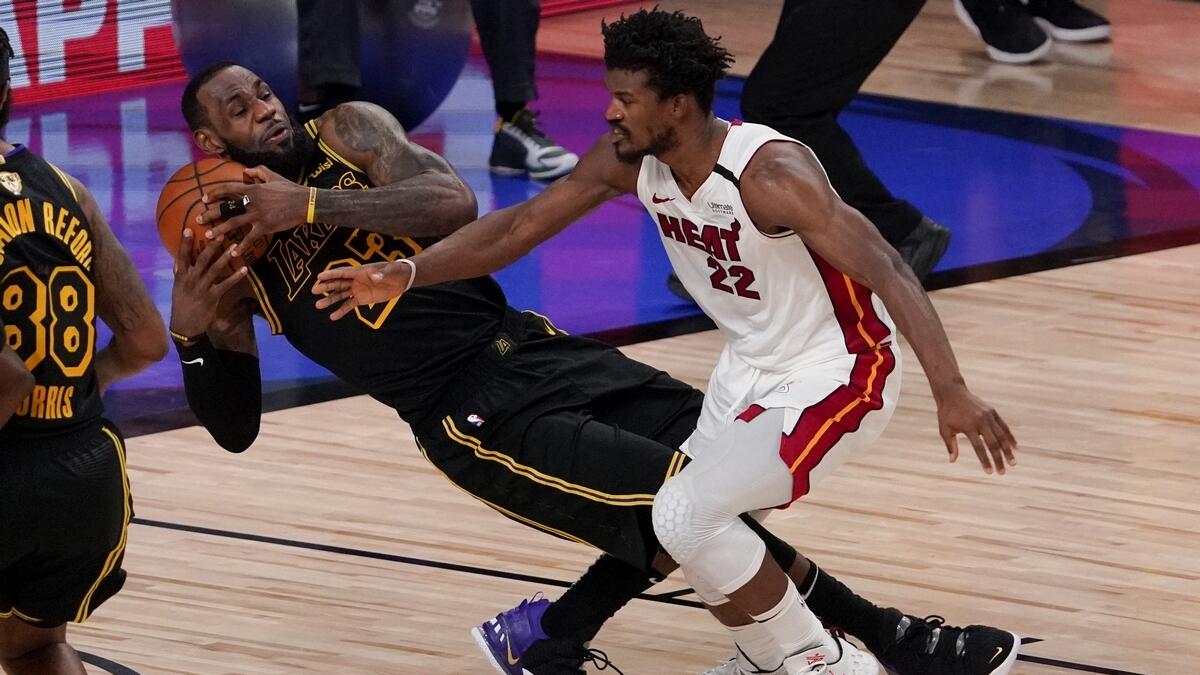 Los Angeles Lakers forward LeBron James pulls rebound away from Miami Heat forward Jimmy Butler during the second half in Game 5 of basketball's NBA Finals