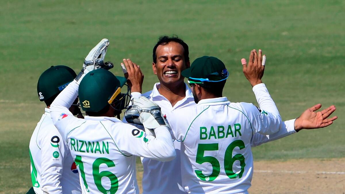 Pakistan's Nauman Ali (second right) celebrates with teammates after taking the wicket of South Africa's Anrich Nortje. (AFP)