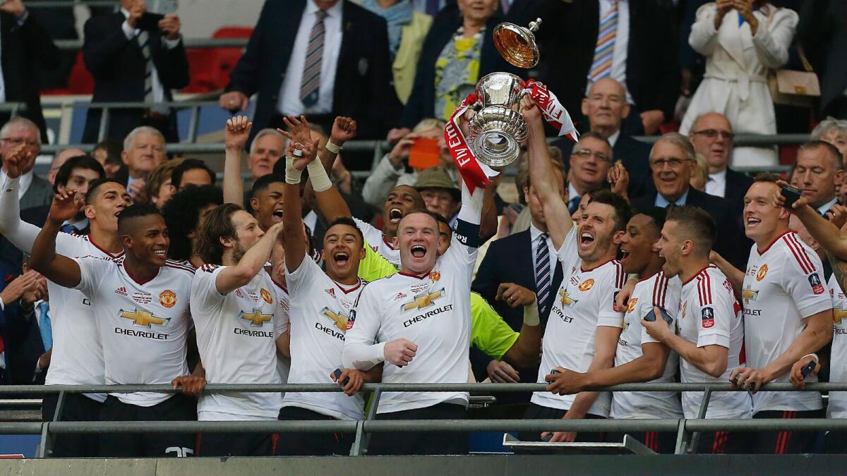 Manchester United's English striker Wayne Rooney (centre left) and Manchester United's English midfielder Michael Carrick lift the trophy as players celebrate their victory after extra time in the English FA Cup final football match between Crystal Palace and Manchester United at Wembley stadium in London on May 21, 2016. Manchester United won the game 2-1, after extra time. - NOT FOR MARKETING OR ADVERTISING USE / RESTRICTED TO EDITORIAL USE/ AFP / IAN KINGTON / NOT FOR MARKETING OR ADVERTISING USE / RESTRICTED TO EDITORIAL USE