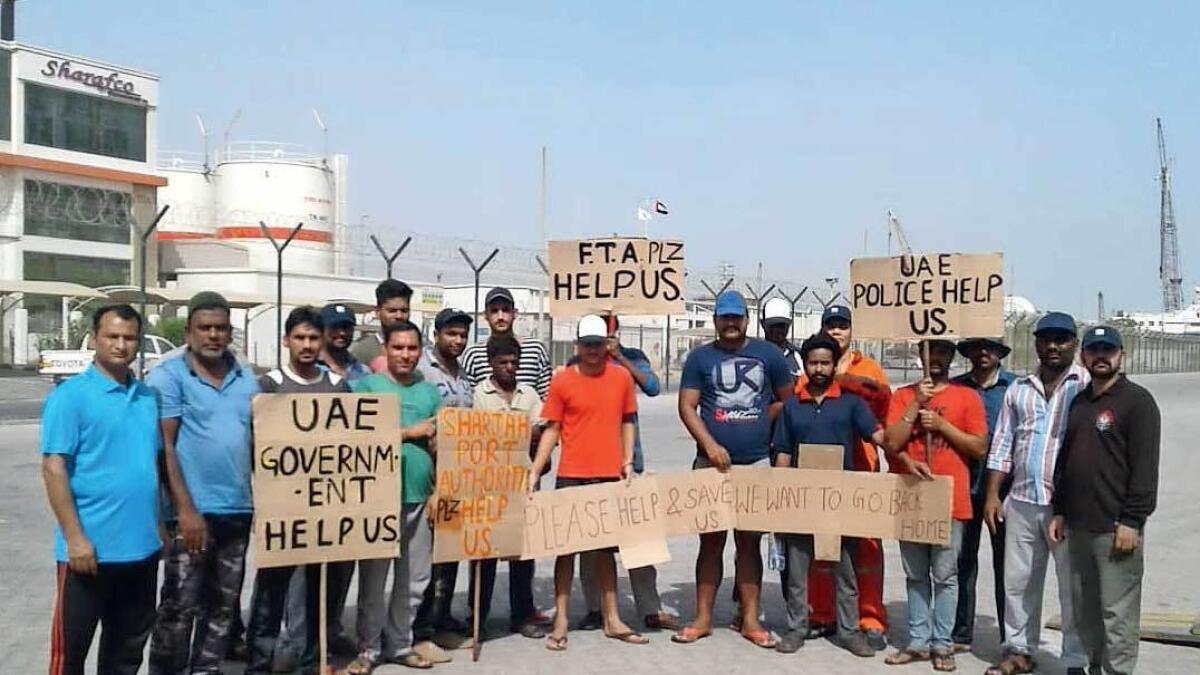 The crew from three vessels hold placards requesting help. All of them except one have been repatriated. — Supplied photo