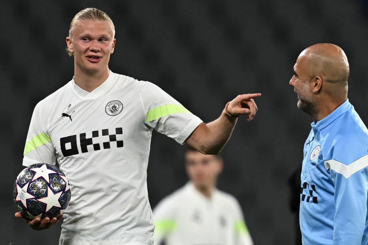 Manchester City manager Pep Guardiola (right) speaks with star striker Erling Haaland during a training session at the Ataturk Olympic Stadium in Istanbul. — AFP