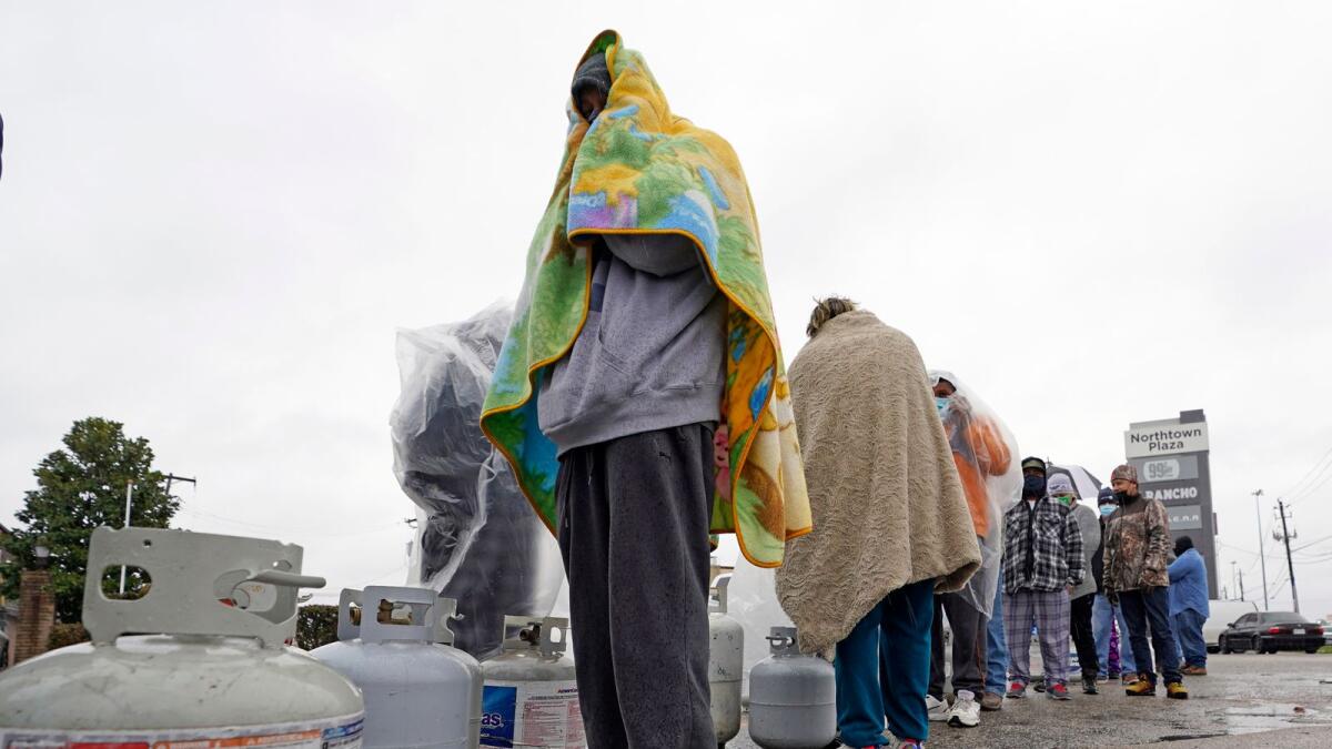 People wait in line to fill their propane tanks on Wednesday in Houston. Customers had to wait over an hour in the freezing rain to fill their tanks.