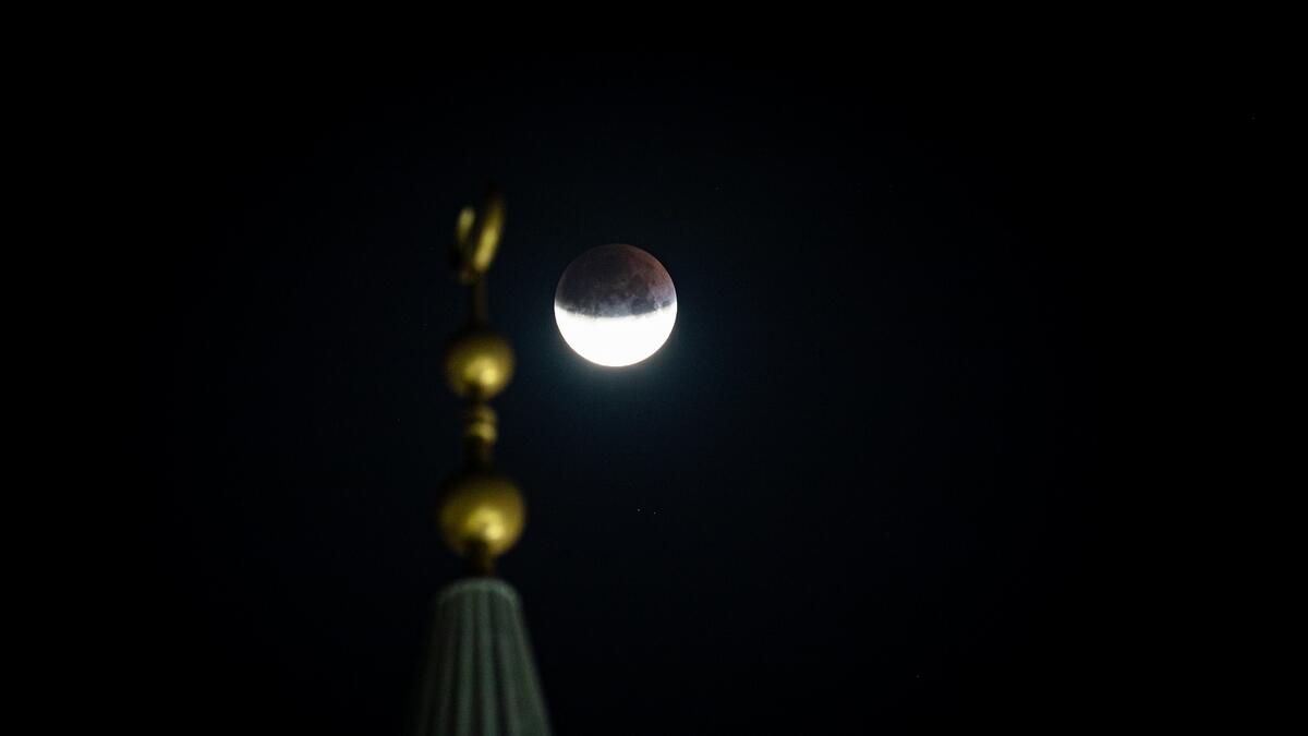 A partial lunar eclipse seen over the Al Farooq Omar Bin Al Khattab Mosque in Dubai.-Photos by Neeraj Murali and M. Sajjad/Khaleej Times