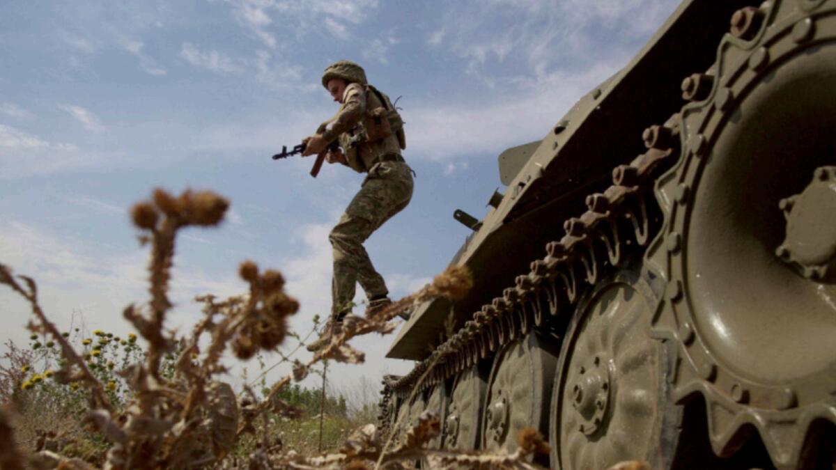 A Ukrainian serviceman jumps from a military vehicle near a frontline in Mykolaiv region. — Reuters