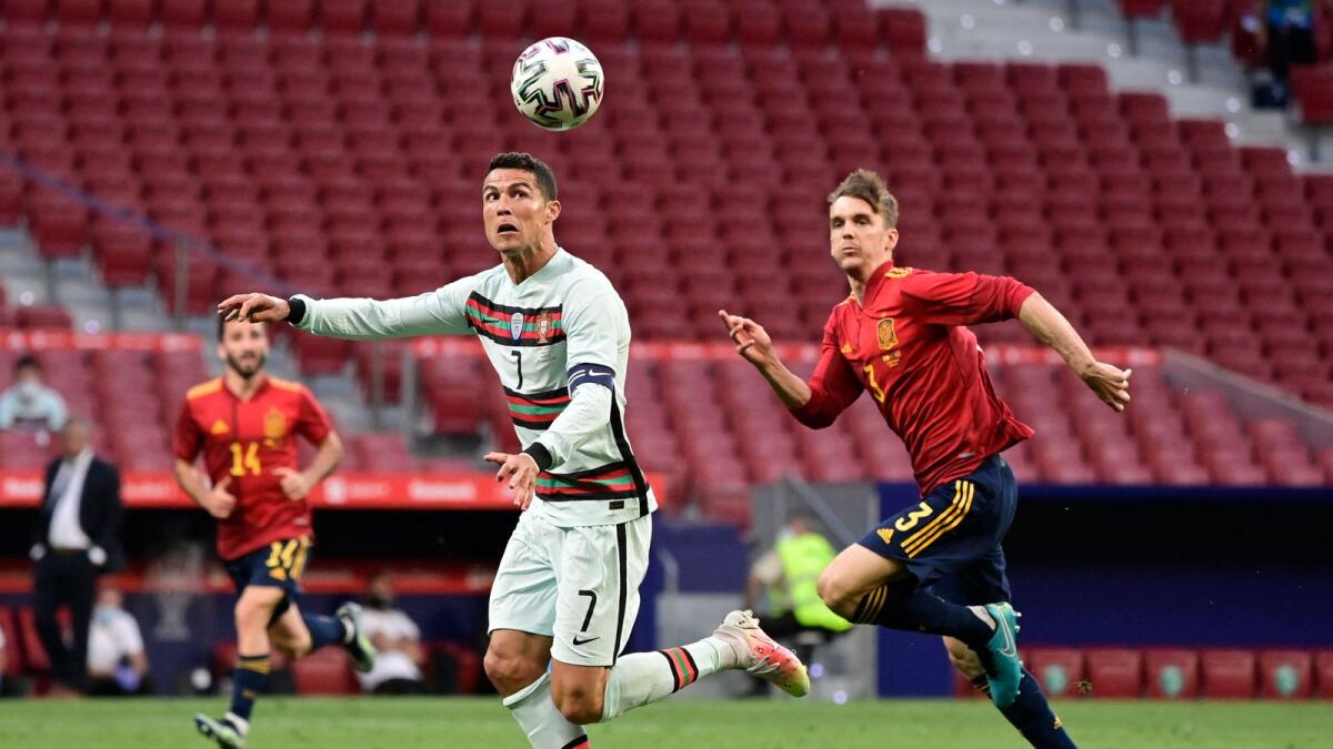 Portugal's Cristiano Ronaldo (left) heads the ball next to Spain's defender Diego Llorente during their international friendly match in Madrid on June 4. (AFP)