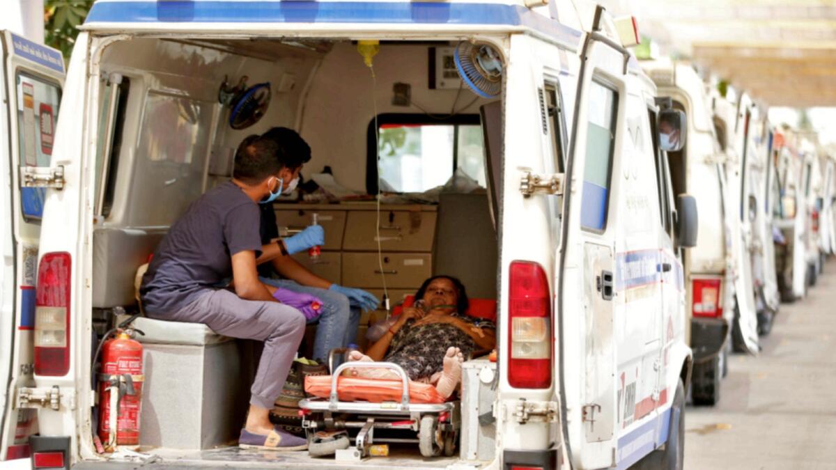 A woman with breathing problem waits inside an ambulance for her turn to enter a Covid-19 hospital in Ahmedabad. — Reuters