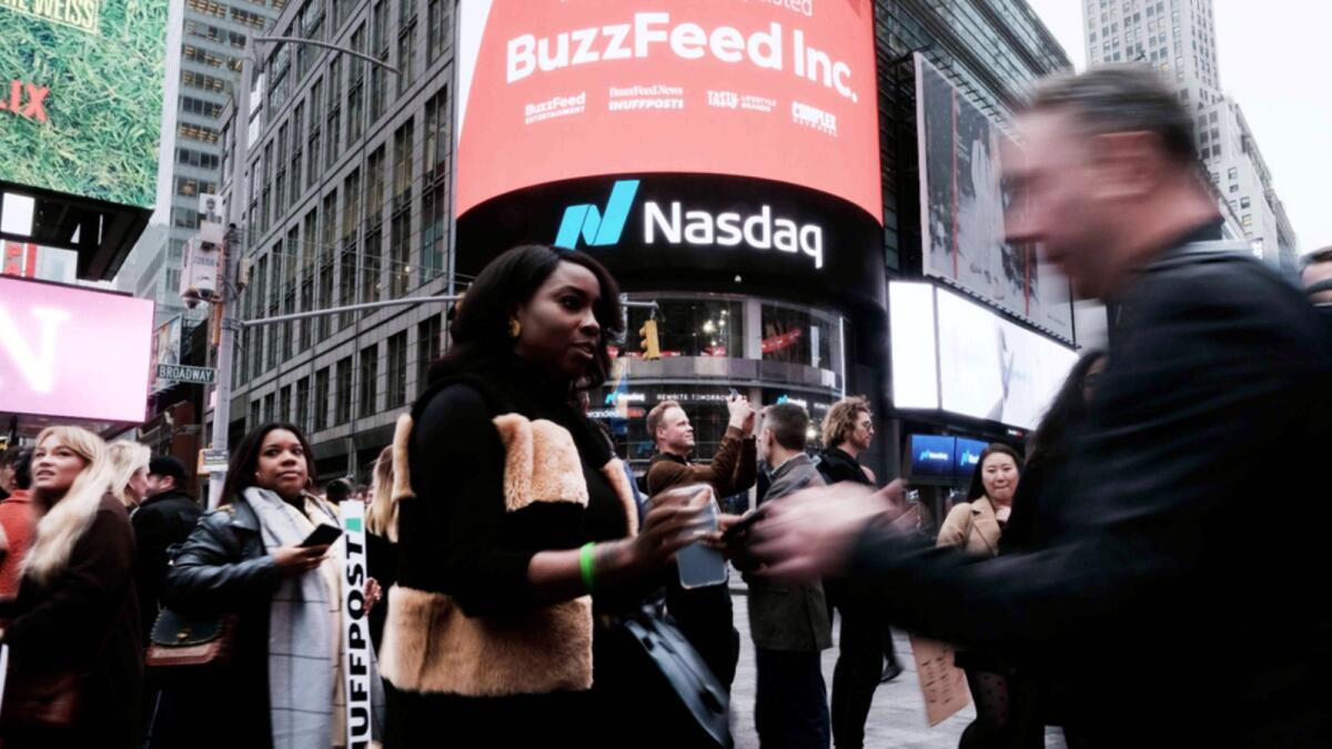 Employees of the media company BuzzFeed gather in front of the Nasdaq market site in Times Square. — AFP