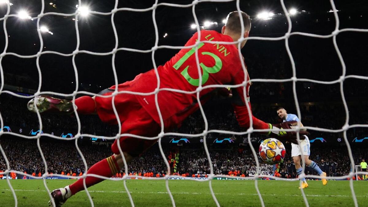 Real Madrid's Ukrainian goalkeeper Andriy Lunin saves a shot by Manchester City's Croatian midfielder Mateo Kovacic during the penalty shootout. - AFP