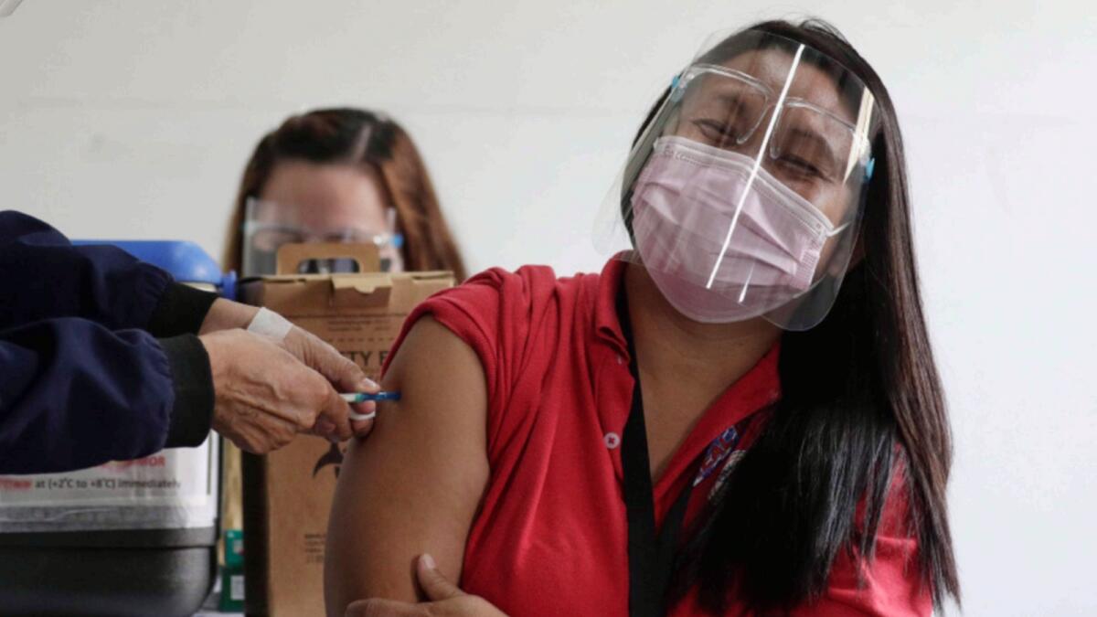A volunteer reacts as she participates in a Covid-19 vaccination dry run in Taguig, Philippines. — AP