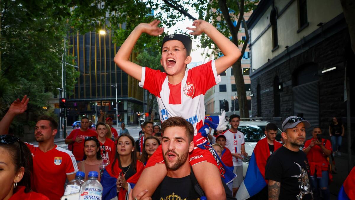 Supporters of Serbia's Novak Djokovic dance and celebrate outside the offices of his legal team in Melbourne on Monday. (AFP)