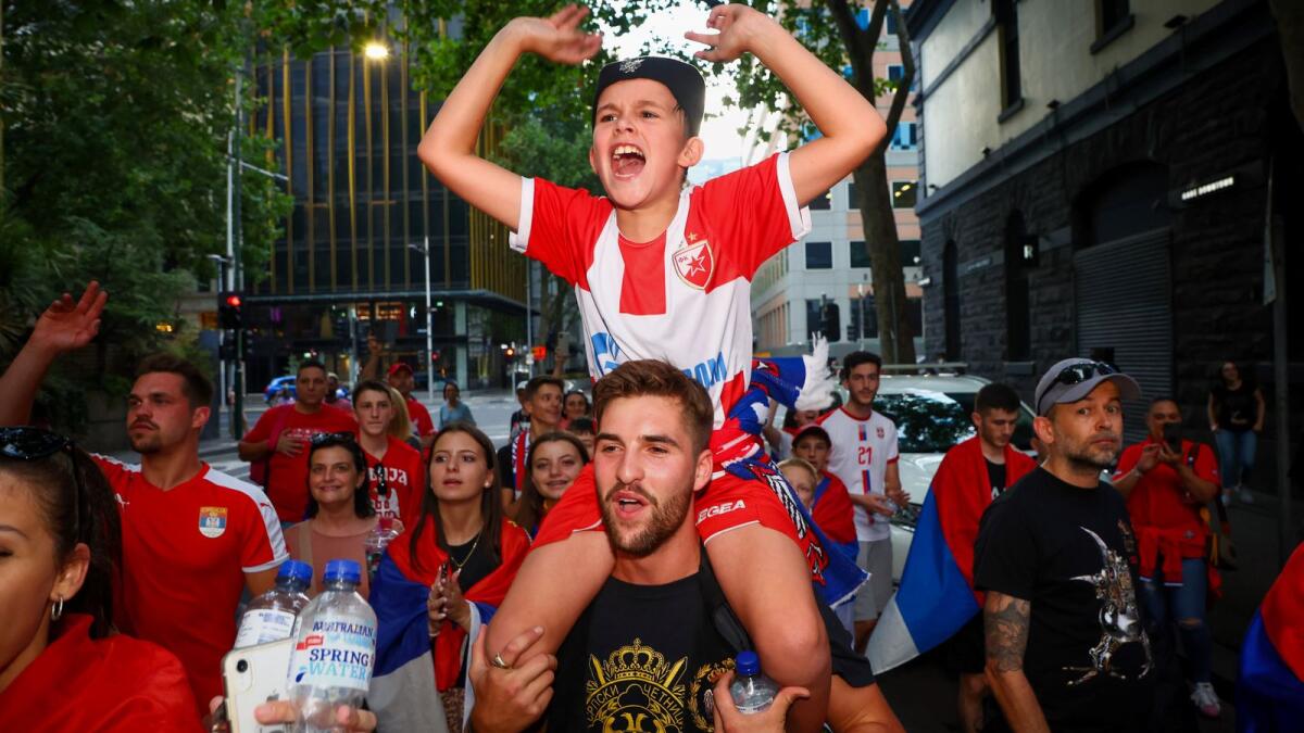 Supporters of Serbia's Novak Djokovic dance and celebrate outside the offices of his legal team in Melbourne on Monday. (AFP)