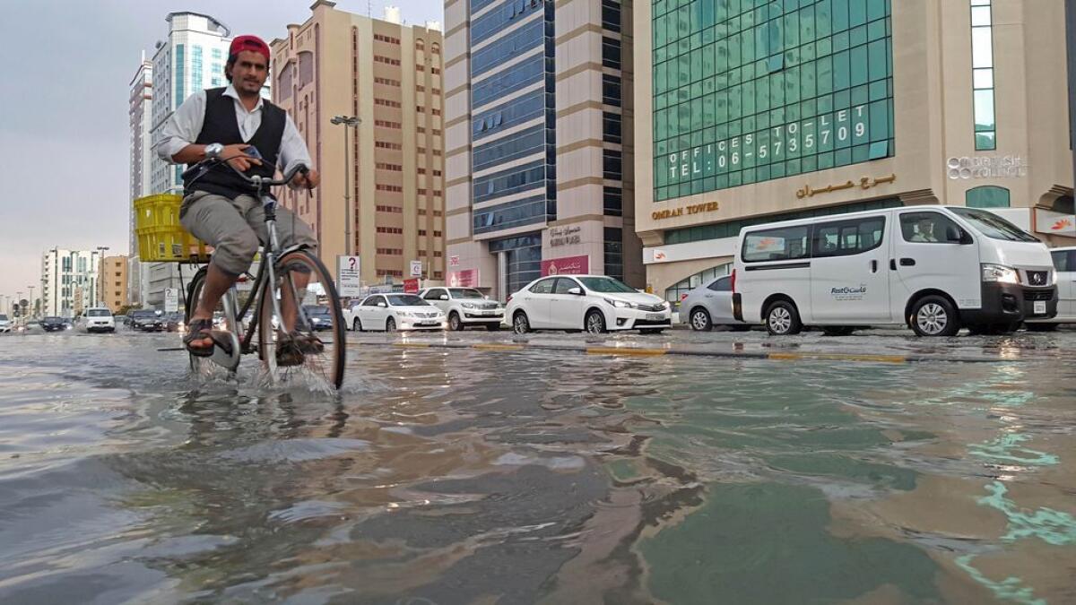 A man trying to cross the water-logged street in Sharjah.– Photo by M.Sajjad/Khaleej Times
