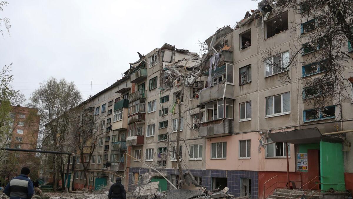 People look at damaged building in Sloviansk, Donetsk region, Ukraine. — AP