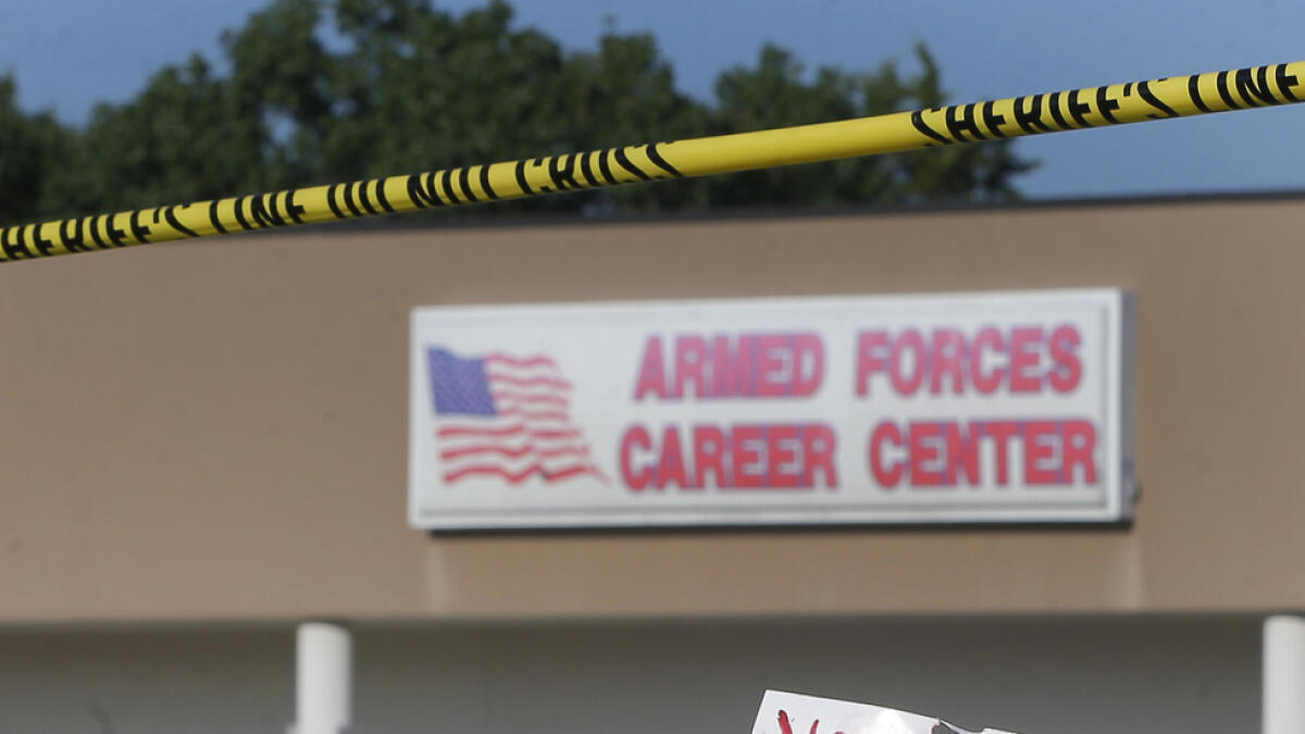 A sign and a flag is placed at a make-shift memorial outside a military recruiting center on Friday, July 17, 2015, in Chattanooga, Tenn. Muhammad Youssef Abdulazeez of Hixson, Tenn.,  attacked two military facilities on Thursday, in a shooting rampage that killed four Marines. (AP Photo/John Bazemore)
