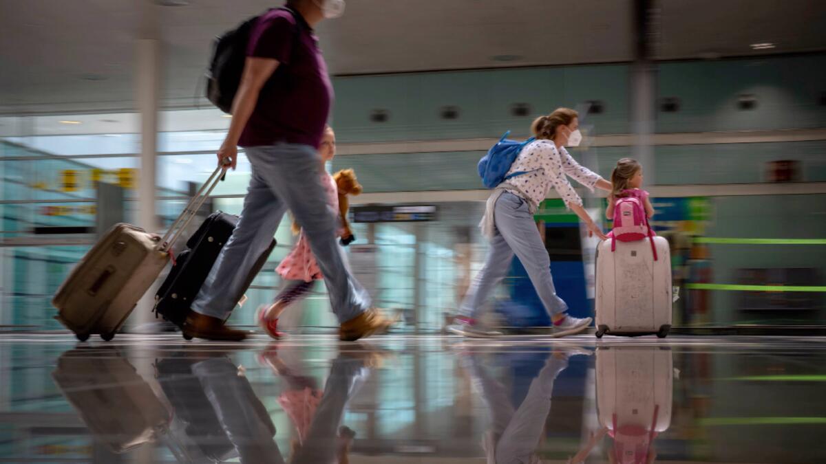 Tourists arrive at Barcelona airport in Spain. — AP file
