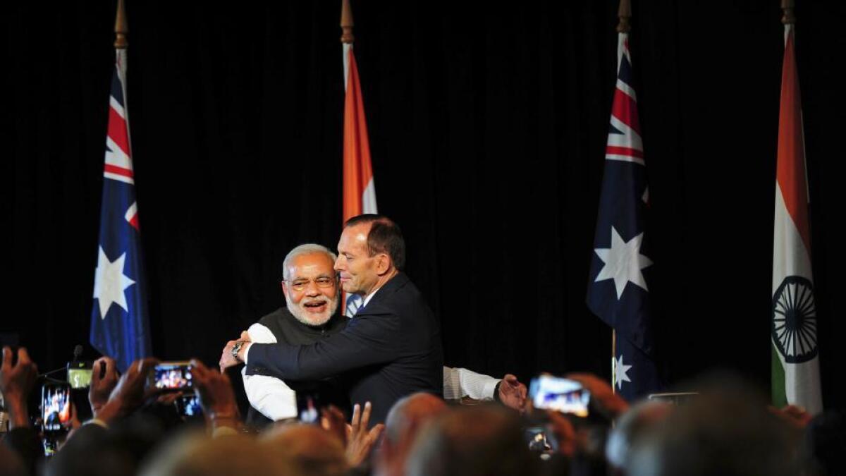 India's Prime Minister Narendra Modi (L) is hugged by Australia's Prime Minister Tony Abbott during a reception at the Melbourne Cricket Ground November 18, 2014.