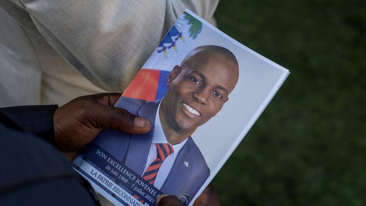 A person holds a photo of late Haitian President Jovenel Moise. (Reuters file)