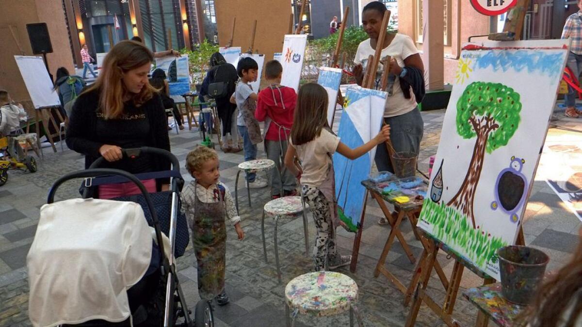 Kids workshop job accomplished: Chiidren visiting the Dubai Canvas Festival are not just posing for pictures but are actually getting their hands dirty with paint.