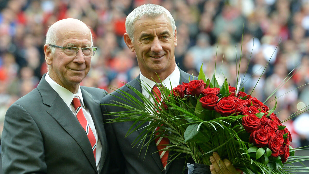 Manchester United's club ambassador Bobby Charlton (L) hands a bouquet of 96 roses to Liverpool's club ambassador Ian Rush (R) before the English Premier League football match between Liverpool and Manchester United at Anfield in Liverpool, north-west England on September 23, 2012. The 96 roses represent the 96 supporters who died in the 1989 Hillsborough disaster.AFP PHOTO/PAUL ELLISRESTRICTED TO EDITORIAL USE. No use with unauthorized audio, video, data, fixture lists, club/league logos or ?live? services. Online in-match use limited to 45 images, no video emulation. No use in betting, games or single club/league/player publications.