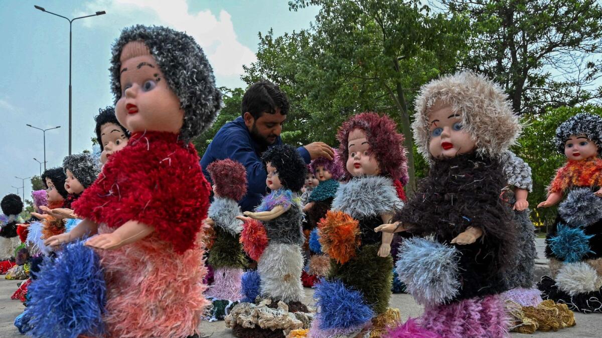 A vendor selling dolls waits for customers along a roadside in Peshawar. If confirmed, a series of investments worth $25 billion would be the biggest ever by Saudi Arabia in Pakistan. — AFP