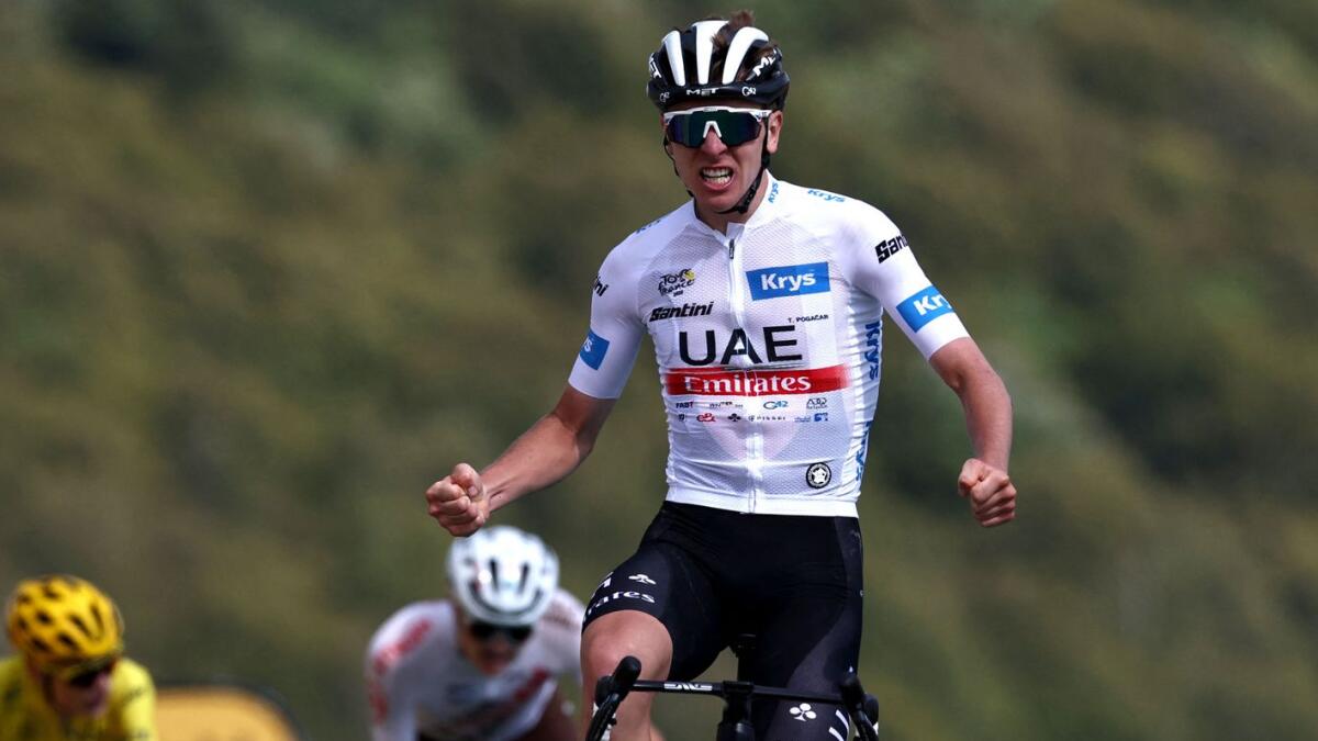 UAE Team Emirates' Slovenian rider Tadej Pogacar wearing the best young rider's white jersey celebrates as he crosses the finish to win the 20th stage of the 110th edition of the Tour de France. - AFP