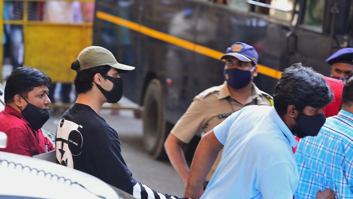 Bollywood actor Shah Rukh Khan's son Aryan Khan is being escorted by law enforcement officials outside the Narcotics Control Bureau (NCB) office in Mumbai. Photo: AFP