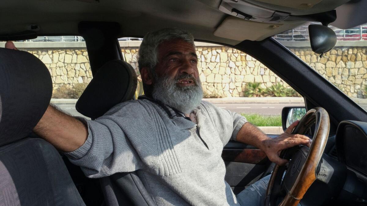 Cab driver Abed Omayraat, talks during an interview with Reuters as he drives his cab in Beirut, Lebanon, on December 9, 2022. — Reuters