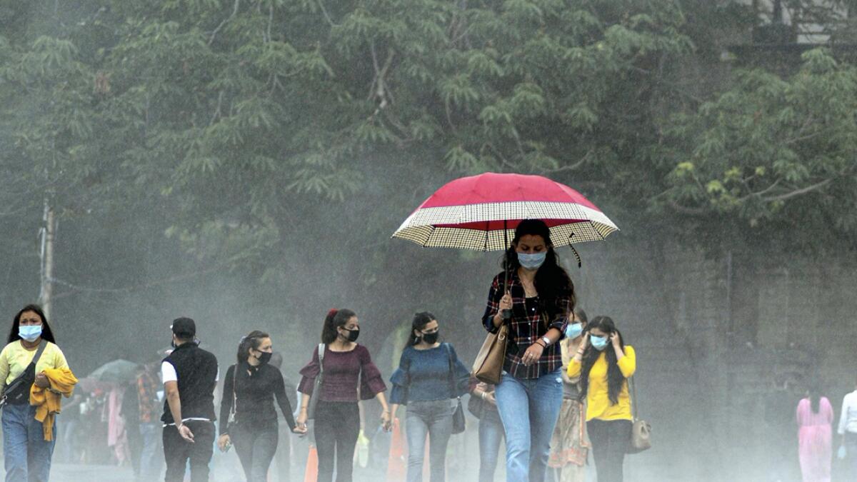 People walk along the ridge during rainfall, in Shimla, India. Photo: PTI