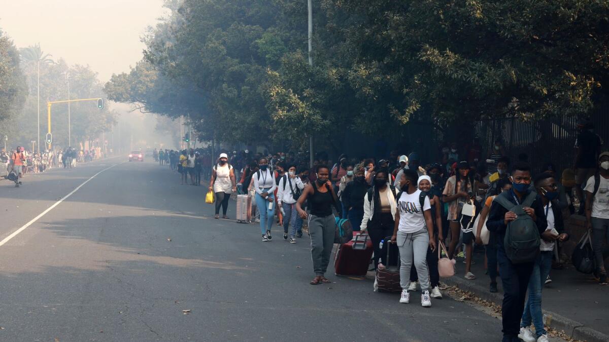 Students make their way after evacuating from their residence at the University of Cape Town, South Africa, on Sunday.