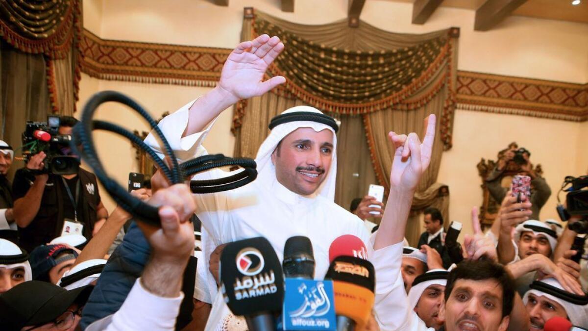 Kuwaiti candidate and former parliament speaker Marzouq al-Ghanem (C), celebrates with his supporters following the announcement of his victory in the parliamentary election, in Kuwait city