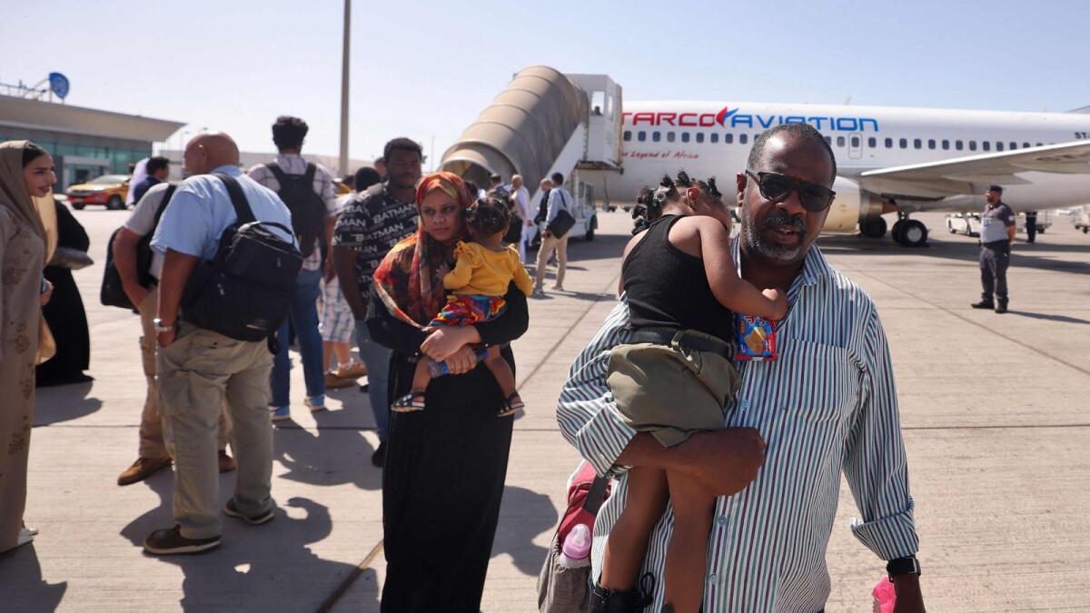 People fleeing conflict in Sudan are welcomed by Emirati officials in Abu Dhabi after an evacuation flight. — AFP file