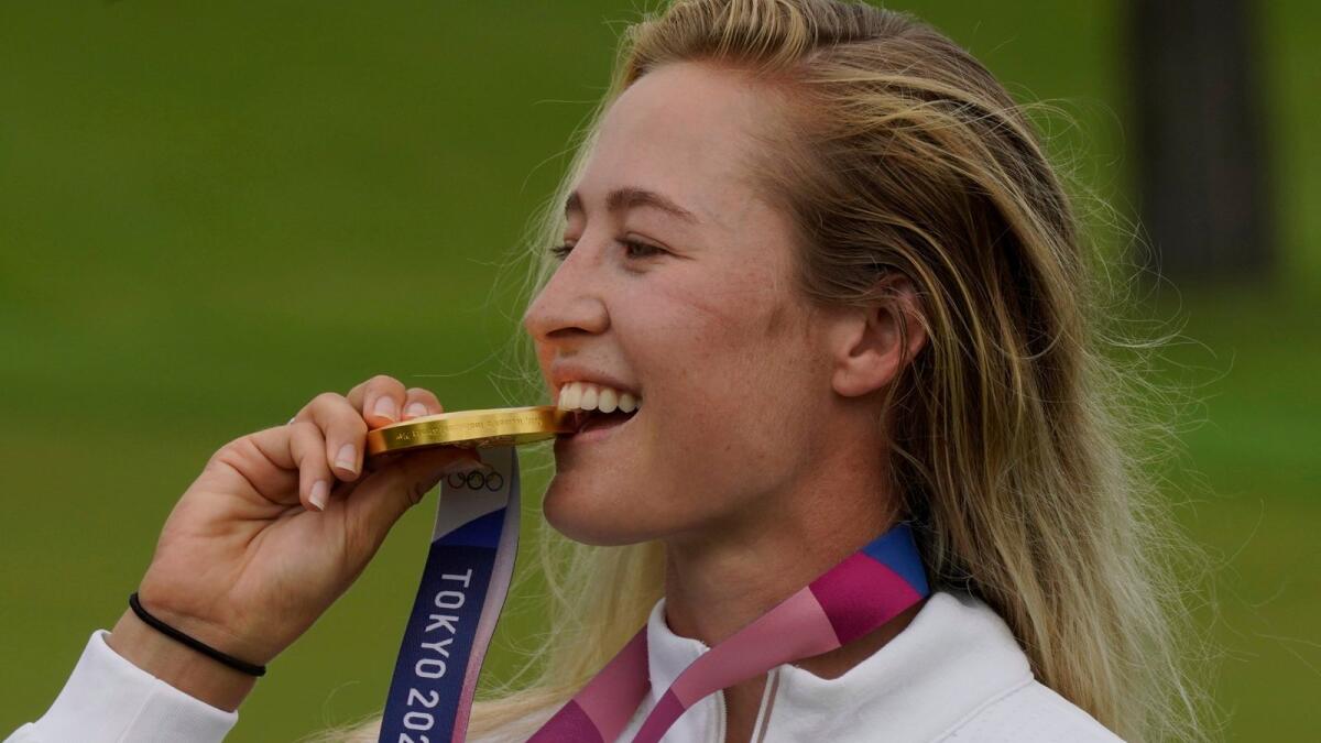 Nelly Korda bites her golf gold medal. — AP