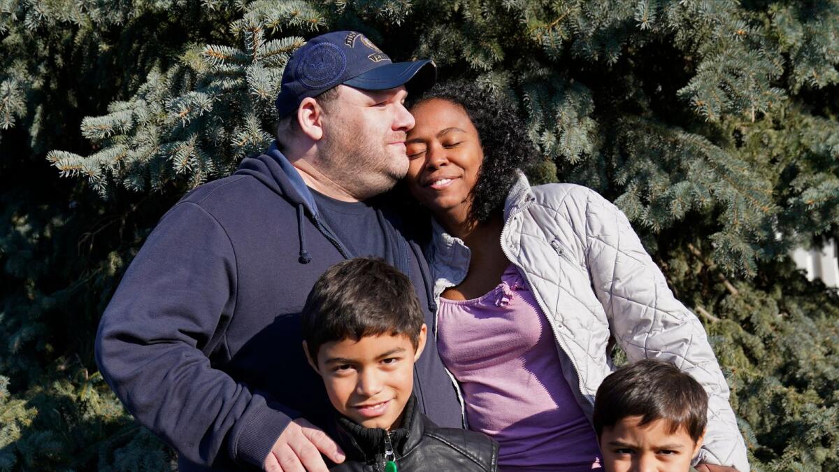 Aaron Crawford, his wife Sheyla and their sons, Sornic, left, and Gabriel, stand for a photograph outside their Apple Valley, Minn., home on  Nov. 21, 2020. The couple turned to a Minnesota nonprofit, 360 Communities, part of Feeding America's food bank network, when the pandemic's economic fallout put them in peril.