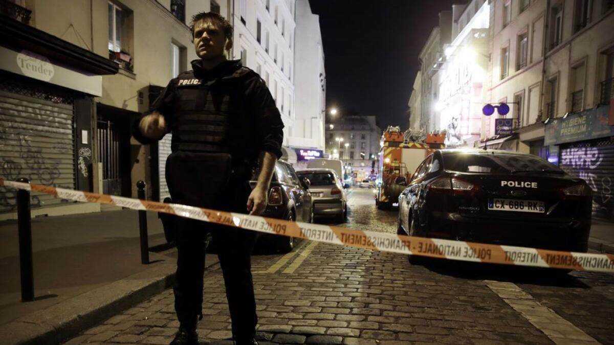 A policeman stands behind a cordon blocking the street near the site of an attack in a restaurant in Paris.