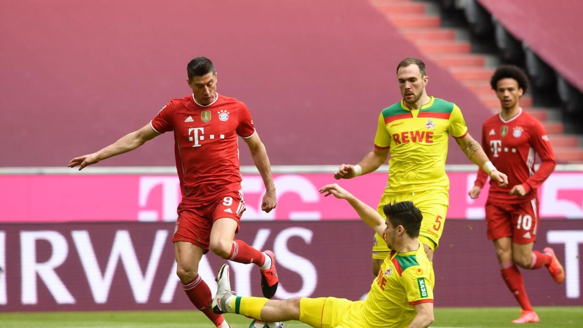 Bayern's Robert Lewandowski (left) and Cologn's Jorge Merz challenge for the ball during a German Bundesliga match. — AP