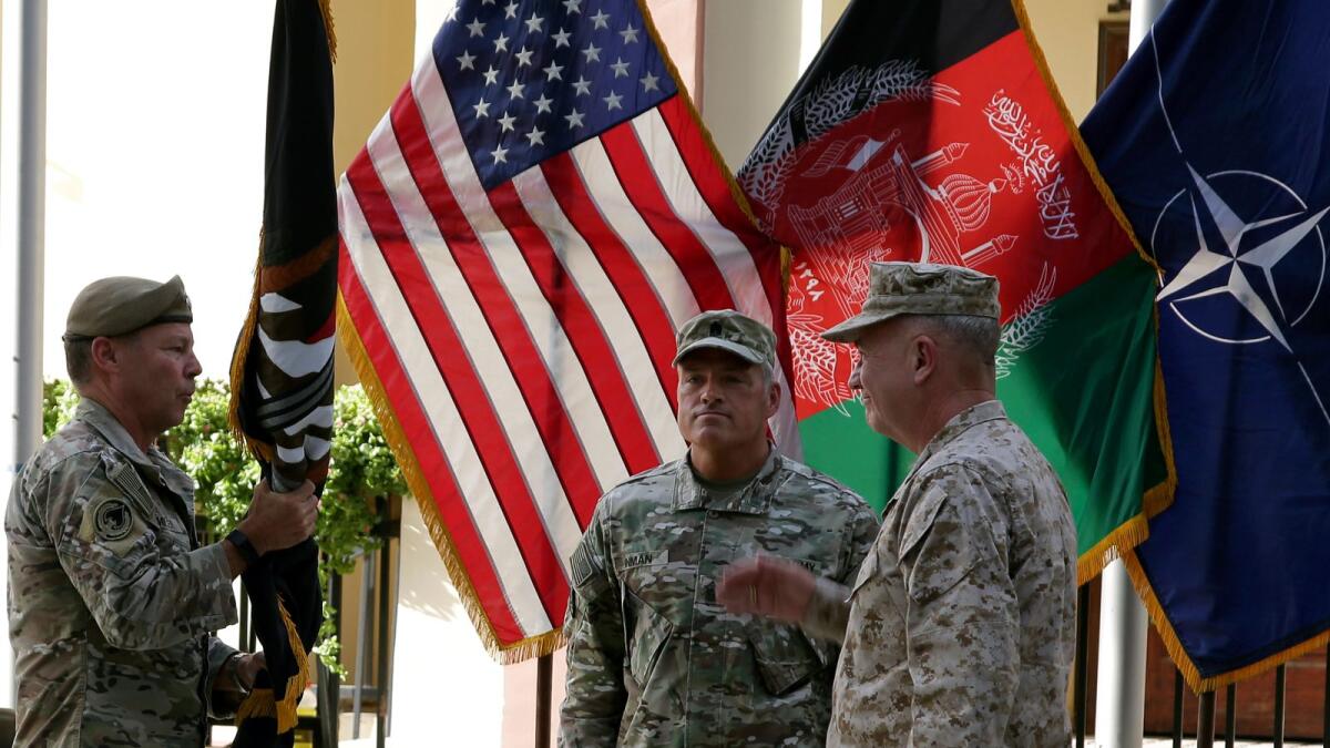 US Army Gen. Scott Miller, the top US commander in Afghanistan, hands over his command to Marine Gen. Frank McKenzie, the head of US Central Command, at a ceremony at Resolute Support headquarters in Kabul on Monday.