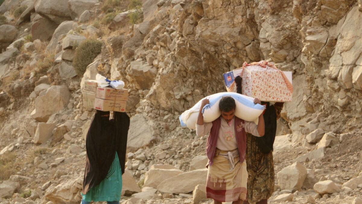 Yemenis carry relief supplies as the Houthis besiege the city of Taiz in 2016. — AP file