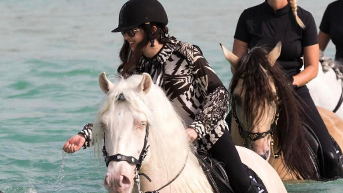 The young Sheikha Maryam riding down Dubai's beach with her sisters and surfers.