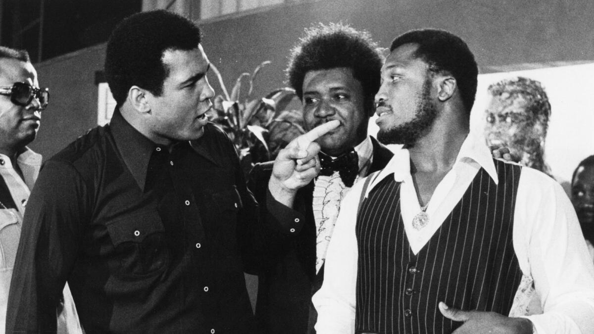 Sports promoter Don King stands between Muhammad Ali (left) and Joe Frazier in New York on July 17, 1975. — AP file