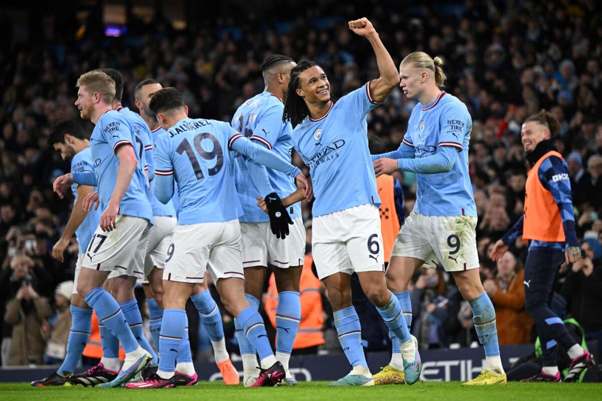 Manchester City defender Nathan Ake celebrates with teammates after scoring a goal against Manchester City. -- AFP