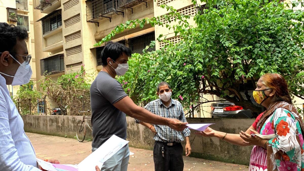 Bollywood actor Sonu Sood interacts with needy people outside his residence amid the coronavirus pandemic in Mumbai on May 23, 2021 (Photo: AFP)