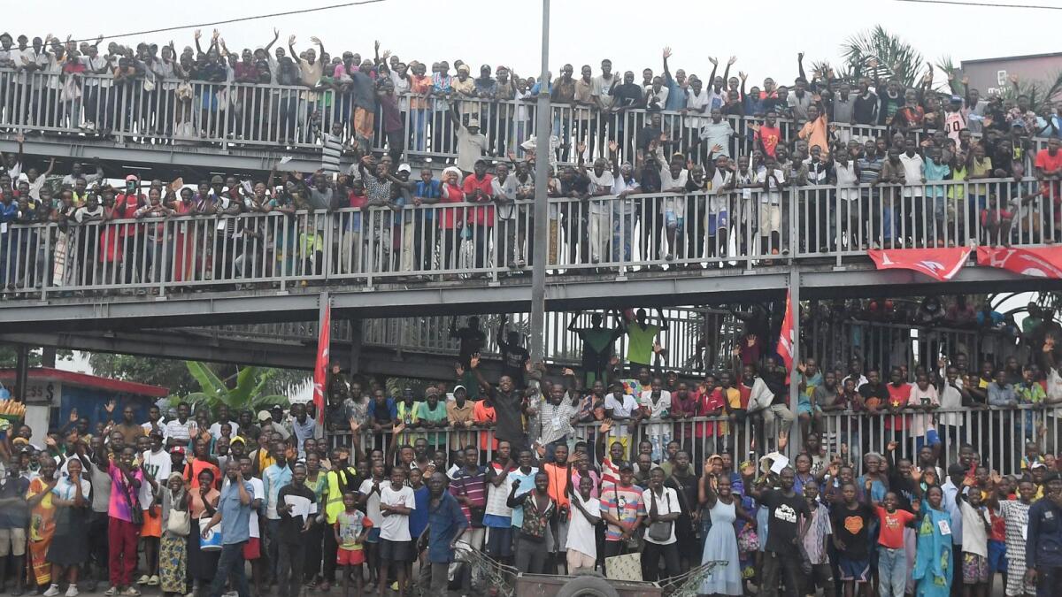 People gathering on the side of the road wave as Pope Francis departs the N'djili International Airport in Kinshasa, Democratic Republic of Congo (DRC), on Tuesday.  — AFP