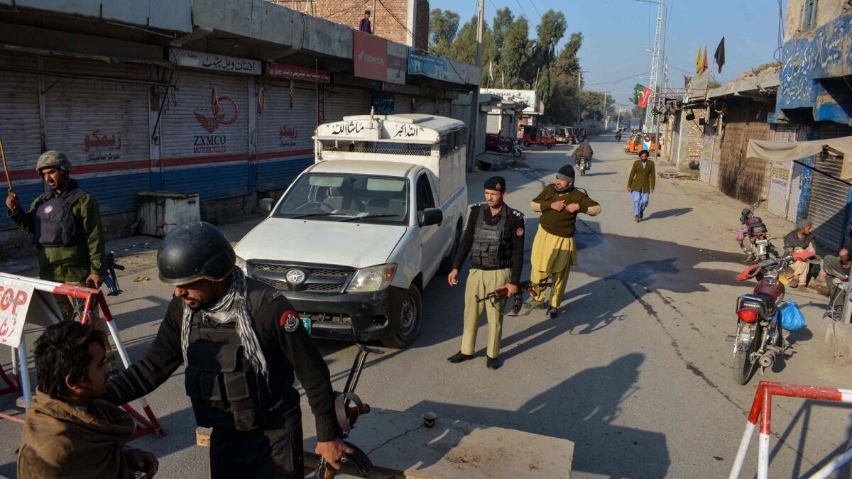 Police stand guard along a road they blocked after Taliban militants seized a police station in Bannu. — AFP