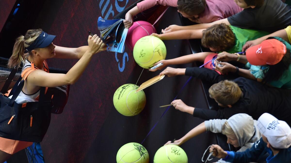 Maria Sharapova signs autographs for fans following her win against Lauren Davis.  