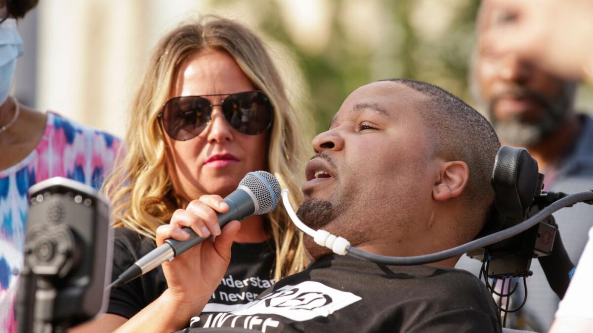 Jerime Mitchell speaks to the crowd as his wife Bracken holds the microphone during a protest against police brutality at Greene Square in Cedar Rapids, Iowa.